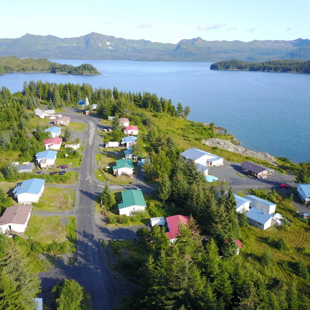 Arial image of houses with lake and mountains in background
